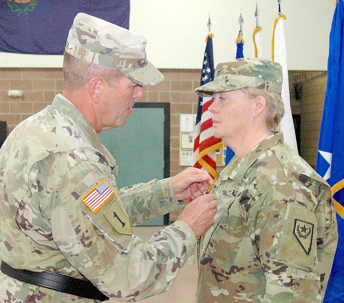 Retired Brig. Gen. Zachary Doser, left, presents Col. Mary Devine with the Meritorious Service Medal in a change of command ceremony in 2018.