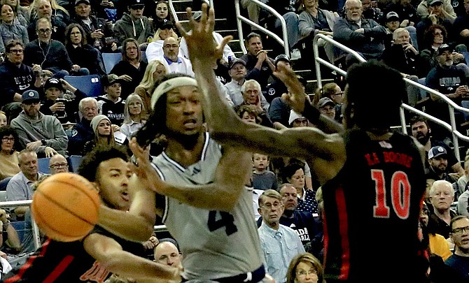 Nevada's Tre Coleman (4) looks for an open teammate as UNLV's Kallib Boone defends during their Saturday night game at Lawlor Events Center.