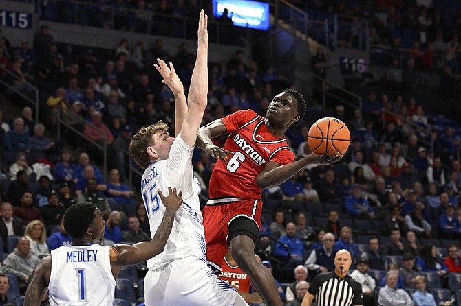 Dayton’s Enoch Cheeks, right, goes up for a shot against St. Louis defenders during a game earlier this month. The Flyers play Nevada on Thursday in Salt Lake City.