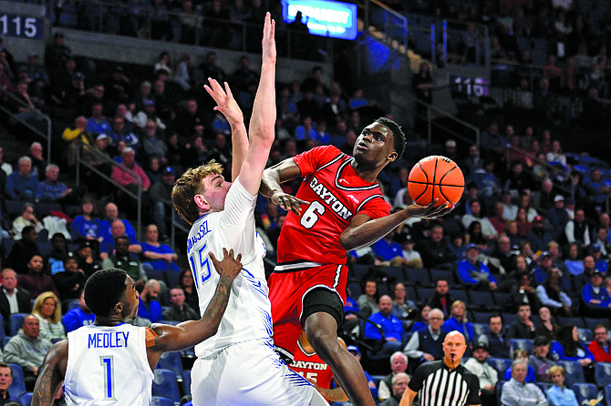 Dayton’s Enoch Cheeks, right, goes up for a shot against St. Louis defenders during a game earlier this month. The Flyers play Nevada on Thursday in Salt Lake City.