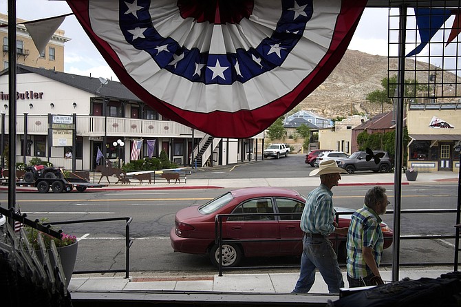 People walk along the main drag in the county seat of Nye County on July 18, 2022, in Tonopah.