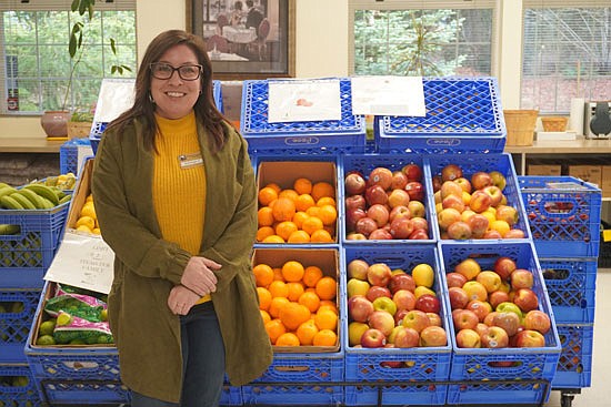 Snohomish Community Food Bank director Ashleigh Cruze stands for a photo in front of the fresh citrus bins of the food bank Tuesday, Jan. 22.