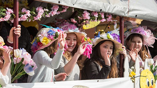Teens in bonnets roll by in one of the many floats in the 2018 Easter Parade.