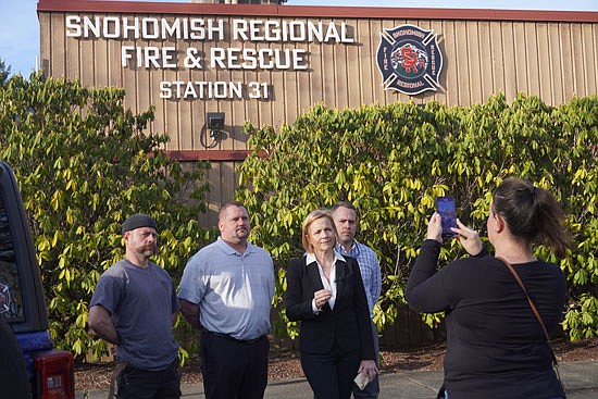 Lauren Petersen records as attorney Jennifer Kennedy issues a video statement after a press conference March 14 at Snohomish Regional Fire & Rescue headquarters in Monroe, flanked by three of the eight firefighters suing their employer for religious discrimination, from left to right, Kevin Gleason, Ryan Stupey and David Petersen.
