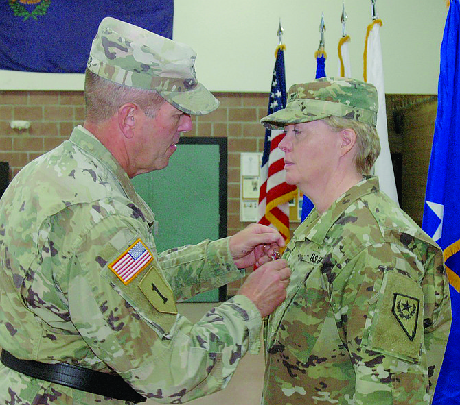 Retired Brig. Gen. Zachary Doser, left, presents Col. Mary Devine with the Meritorious Service Medal in a change of command ceremony in 2018.