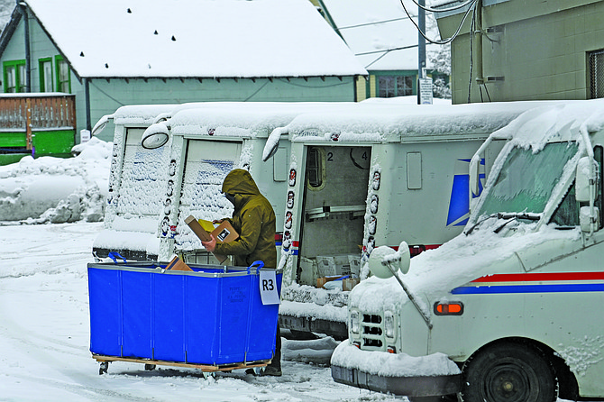 A mail carrier loads a mail truck with mail on March 1 in Lake Tahoe, Calif.