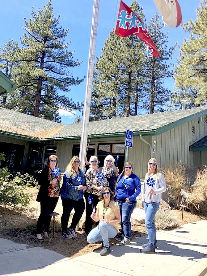 Members of Child Abuse Prevention Council raise the Forgotten Children's Memorial Flag on Wednesday.