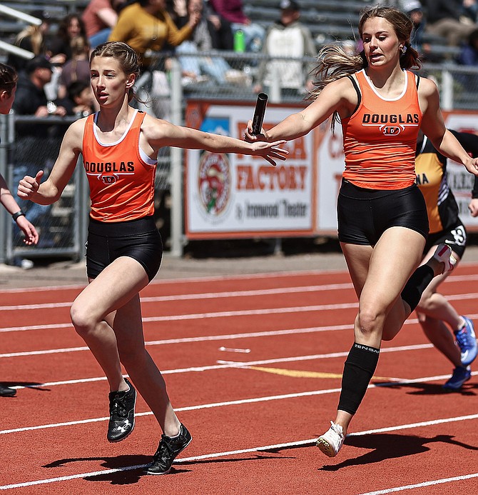 Tiger senior Ava Coons hands the baton to sophomore Grace Strabala during the girls 4x200 relay at the Big George Invitational on Saturday. Coons, Strabala, Elizabeth Gneiting and Bliss Moody won with a time of 1:46.75.