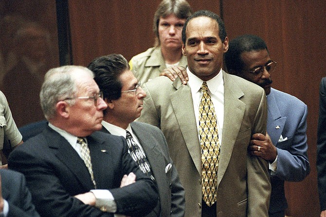 Attorney Johnnie Cochran Jr. holds O.J. Simpson as the not guilty verdict is read in a Los Angeles courtroom during his trial in Los Angeles. Defense attorneys F. Lee Bailey, left, and Robert Kardashian look on.