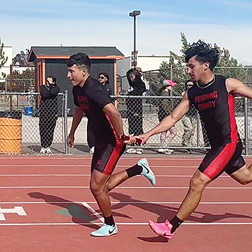Pershing County’s Luis Sanchez hands off the baton to Denzel Zaldivar during the Fernley Invitational on Friday.