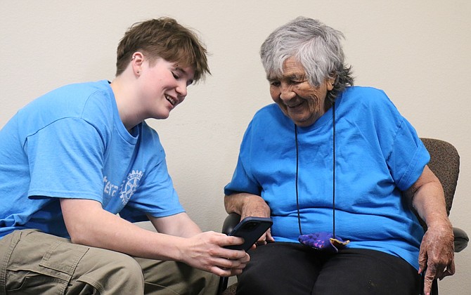 Carson High School junior Jax Whatley, president of the school’s Interact Club, talks to Maggie Marin at the Carson City Senior Center and gives her advice about using her phone.