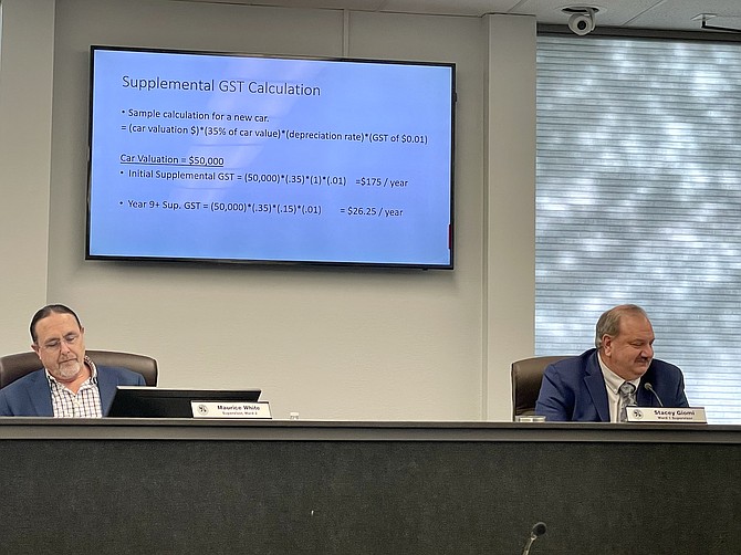 Carson City Supervisors Maurice White, left, and Stacey Giomi review a slide that shows how the proposed government services tax would affect a $50,000 car.