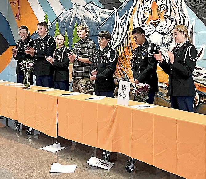 Douglas High School JrROTC cadet Ivan Euceda Bernales stands back after revealing the college he's attending as his fellow cadets applaud at the April 17 ceremony.