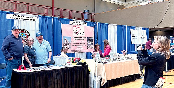 Mikey Andersen, right, with the Carson Valley Chamber of Commerce takes a photo of the East Fork Volunteer Firefighters Association booth at the 2023 Business Showcase.
