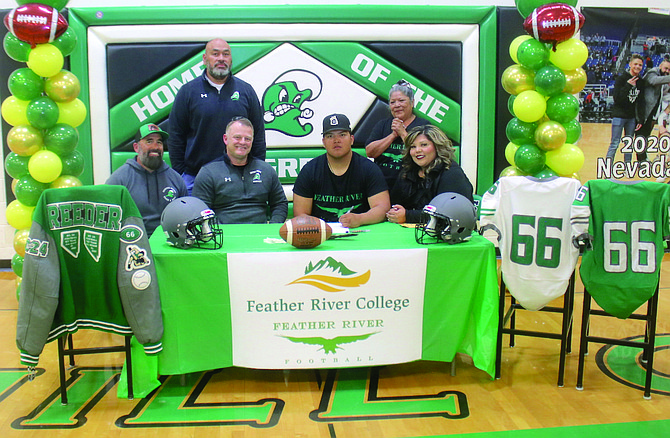 Sean Reeder, center, signs his letter of intent to play football at Feather River College in Quincy, Calif. From left: Coaches Jorge Guerrero, Lalo Otuafi and Brooke Hill, Reeder, his mother Shawntay Fredericks and aunt Marjena Dick.