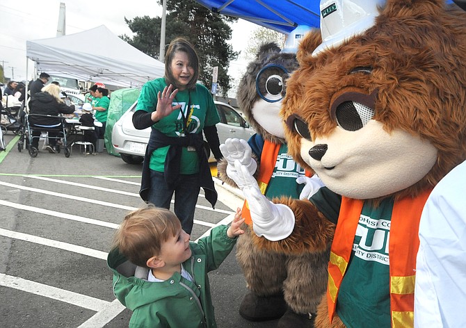 A child is greeted by the PUD’s squirrel mascots Zip and Zap at the PUD’s annual Energy Block Party at the utility’s main office in downtown Everett on Saturday, April 27. The event featured chances to check out various PUD vehicles and equipment as well as demonstrations which showed the dangers of work under power lines and avoiding down power lines. This year’s event also featured an electric vehicle car show along with displays by the Everett Fire Department and a number of law enforcement agencies.