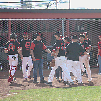 The Pershing County Mustangs meet in front of the dugout between innings.