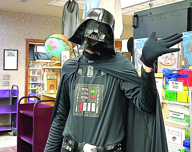Before he was but the learner, but now he’s the reader. Darth Vader at last year’s May the Fourth storytime at the Douglas County Public Library.