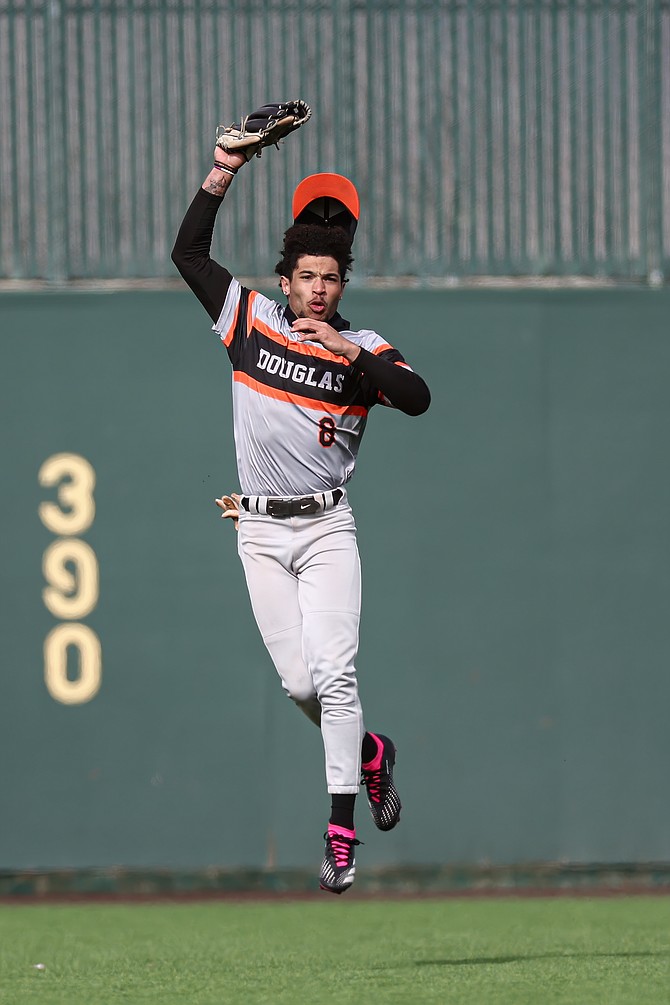 Douglas High School senior Thomas Young leaps to make a catch in the outfield earlier this season. Young will head to San Diego State in the fall where he will continue his baseball career.