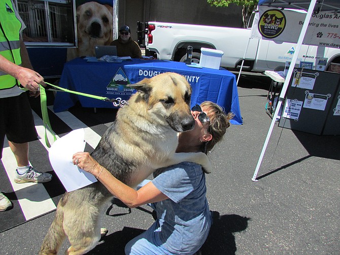 Nora, a 1-year-old German shepherd, gives Minden resident Erin Reardon a hug during the “Puppies on Main” adoption event Tuesday at Coffee on Main. R-C photo by Sarah Drinkwine