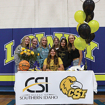 Lowry High School senior Savannah Stoker with her basketball and softball teammates, as she signs with CSI.