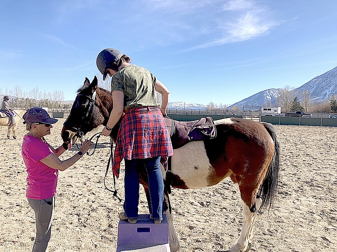 A Between Horses and Humans volunteer helps a student.