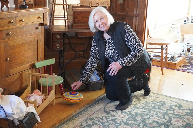 Everett Museum of History volunteer docent and board member Joan Packard shows a 1940s-era spinning top toy inside the museum’s outpost at the Van Valey House on Wednesday, May 2.