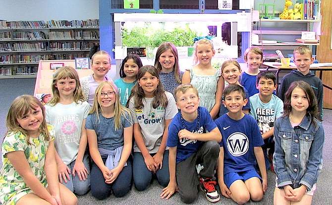 Minden Elementary school third graders sit proudly in front of their hydroponics system where they have grown lettuce, herbs, tomatoes and more in their classrooms.