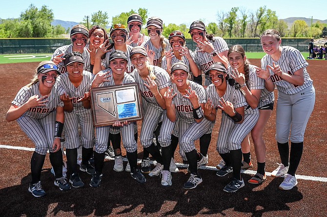 Douglas High School softball holds up the Class 5A North regional title trophy after besting Spanish Springs, 7-0, Saturday. It marks the third consecutive regional title for the Tigers.