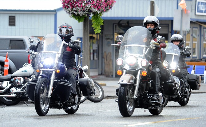 A group of motorcyclists pass by a few of the early arrival bikes as they ride up First Street in Snohomish heading in for the Sky Valley Motorcycle Show in fall 2021.