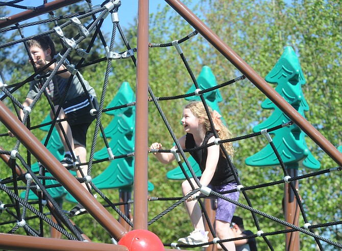 Children ascend the rope climb tower at the new Averill Field playground in Snohomish on Friday, May 10. Hundreds of children along with their parents swarmed the playground after a dedication and ribbon cutting ceremony May 10 which officially opened the new playground. The park project replaced older playground equipment and more.