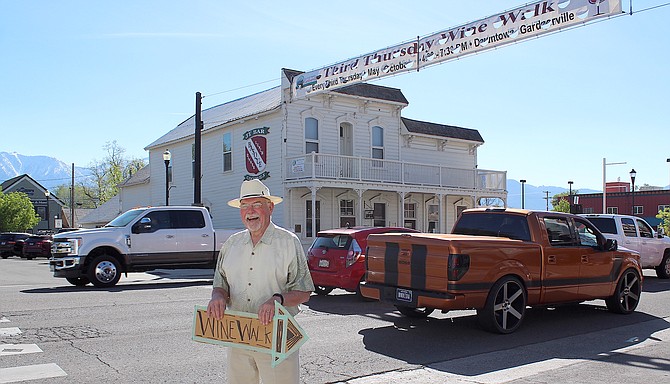 Apprentice sign spinner Dr. Michael Fischer directs wine walkers down Eddy Street to daughter Meredith's Eddy Street Vintage Market on May 18, 2023, in downtown Gardnerville.