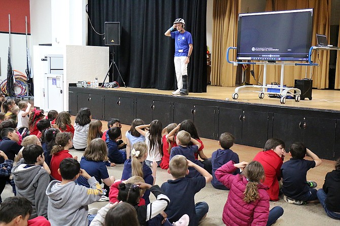 Scott Bohemier, Western Nevada Safe Routes to School coordinator, demonstrates how to wear a bike helmet to Seeliger Elementary School second graders May 10.