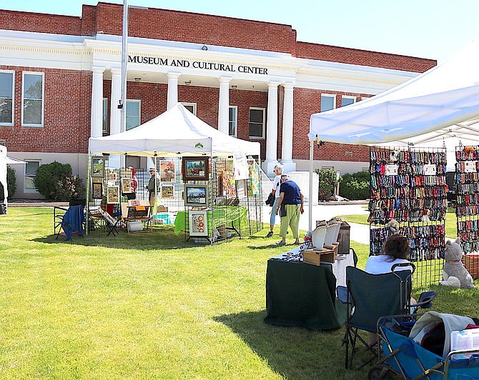 Visitors peruse the booths at Art & Wine on the Green on Saturday morning in Gardnerville.