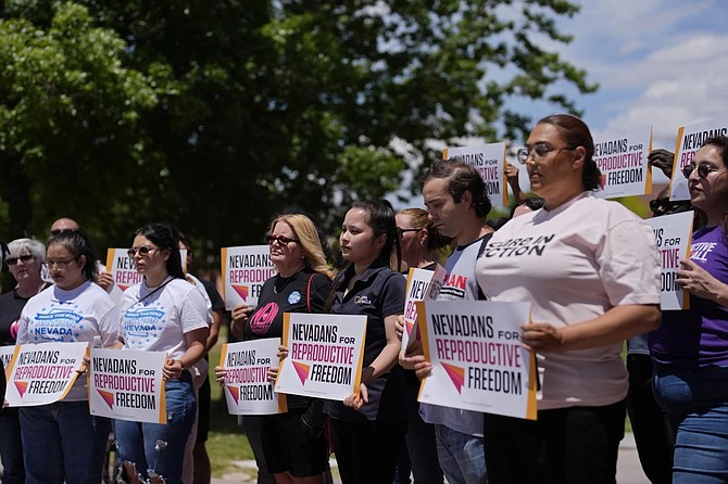 People hold signs during a news conference by Nevadans for Reproductive Freedom on May 20, 2024 in Las Vegas.