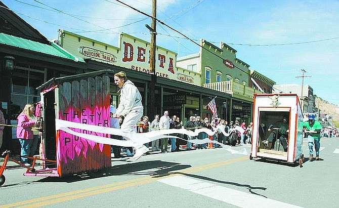 Ryan Camgros, of Grass Valley, Calif., gets caught in the toilet paper finish line during the annual Outhouse Races on Saturday in Virginia City. Camgros was a pusher for Filthy Fill's Party Pooper.