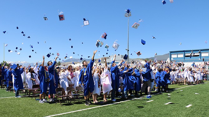Graduates of Carson High School’s Class of 2024 toss their caps on the football field Saturday.