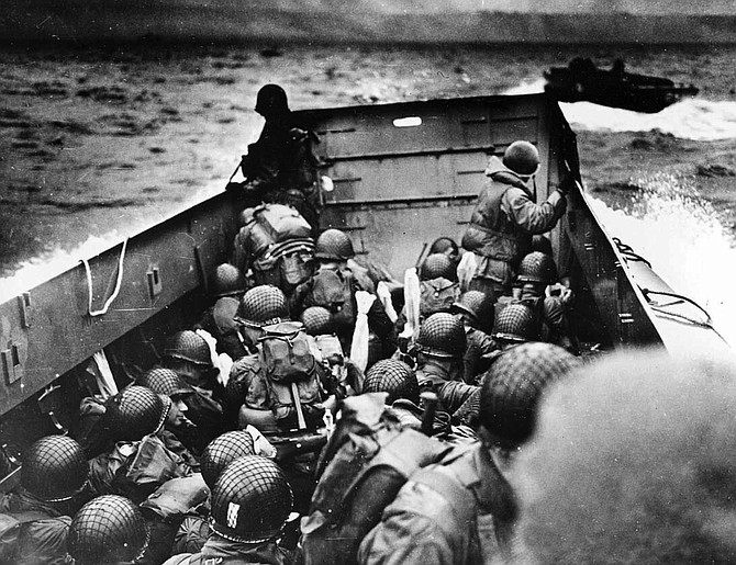 In this photo provided by the U.S. Coast Guard, a U.S. Coast Guard landing barge, tightly packed with helmeted soldiers, approaches the shore at Normandy, France, during initial Allied landing operations on June 6, 1944.