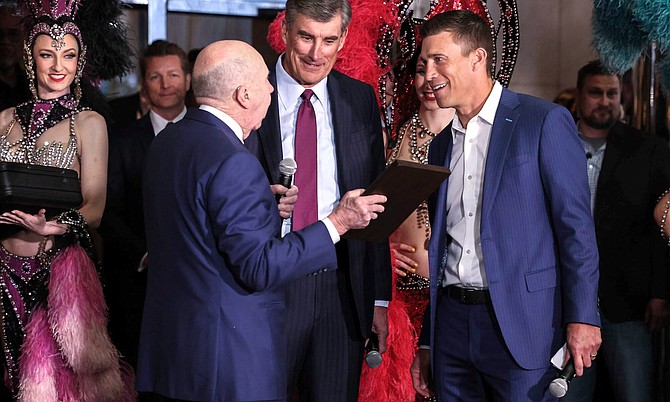Gaming legend Jack Binion left, presents Caesars Entertainment Chairman Gary Carano and company President Anthony Carano a plaque with a horseshoe during the grand opening celebration at Horseshoe Las Vegas, formerly Bally’s Las Vegas, on March 24, 2023.