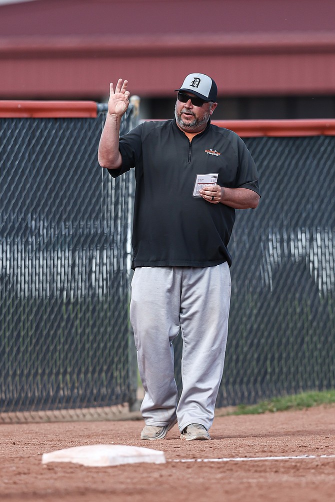 John Glover, seen here relaying signs during a softball game, announced he will has stepped down as Douglas High School's athletic director and softball coach to take the principal job at Eureka High School.