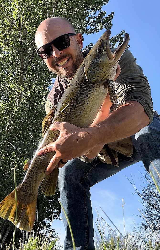 Valley resident Michael McQuain flexing on his absentee fishing buddy J.D.  with this 7-pound, 27-inch German brown trout he caught in the Carson River on May 29.