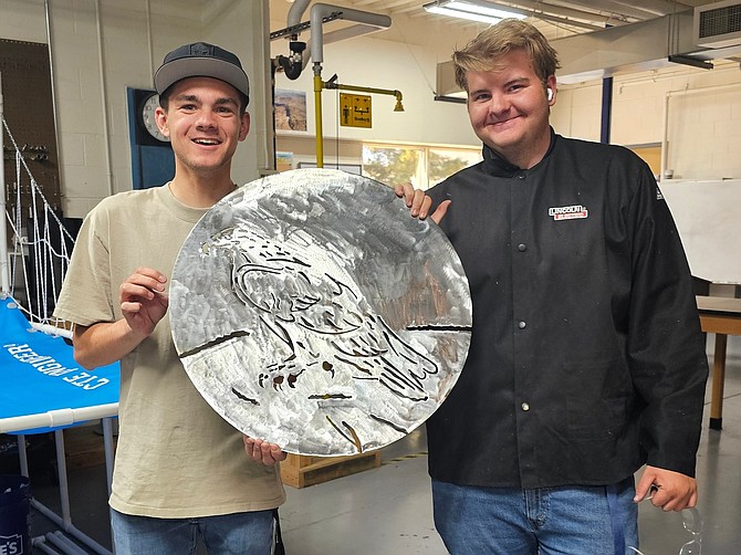 Engineering students Aaron Whitt, junior, and Ben Morrison, senior, demonstrate the metal artwork they created for the Carson City Chamber of Commerce’s leadership class as part of its project to renew Mills Park Amphitheater and Memorial.