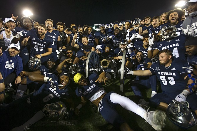 The Nevada football team celebrate with the Fremont Cannon after its 51-20 win over UNLV on Oct. 29, 2021, the Wolf Pack’s most recent win in the series.