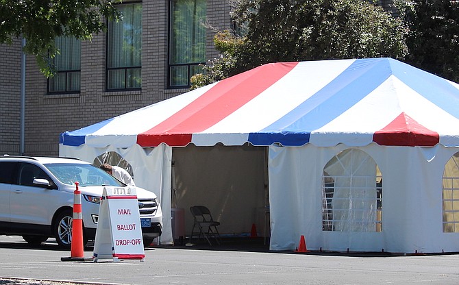 Voters drop off the ballots they received in the mail at the Election Tent behind the Douglas County Courthouse on June 7, 2024.