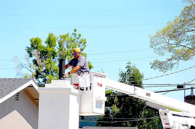 A Minden worker installs the metal stanchion that holds the globe on one of the pillars at the town's official entrance on Tuesday. With a coat of stucco and the lights, those pillars should last for a couple of decades at least.