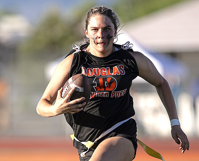 A Douglas High School senior runs with the ball in the Mountain Madness flag football competition that precedes graduation. The Class of 2024 won for the second year in a row, after winning as juniors last year.