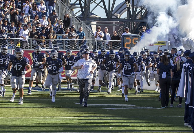 Former Nevada head coach Brian Polian leads the Wolf Pack onto the field before a game against Fresno State in 2016. Polian finished 5-7 that season, his final one at Nevada.