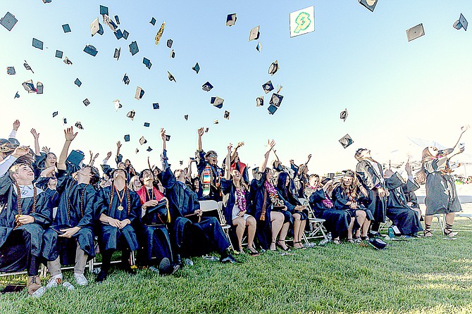 Graduates throw their mortar boards into the air to celebrate receiving their degrees on Friday at Douglas High School in Minden.