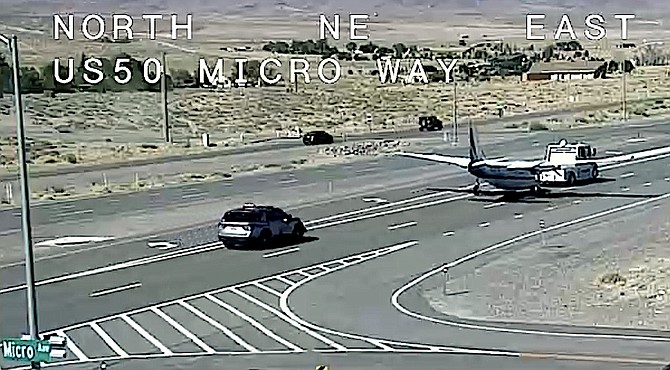 A twin-engined aircraft is towed east on Highway 50 to the Silver Springs Airport.