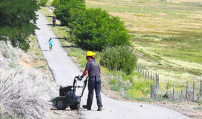 Members of East Fork Fire Protection District's Genoa Peak crew clear brush from along the Genoa Vista Trail on Wednesday morning.